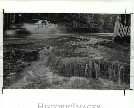 1989 Press Photo Water flows over a washers driveway in Gates Mills Brigham Rd. - Historic Images