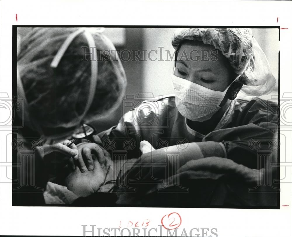 1991 Press Photo Dr. Feng watches the suturing of breast of Deborah Carver - Historic Images