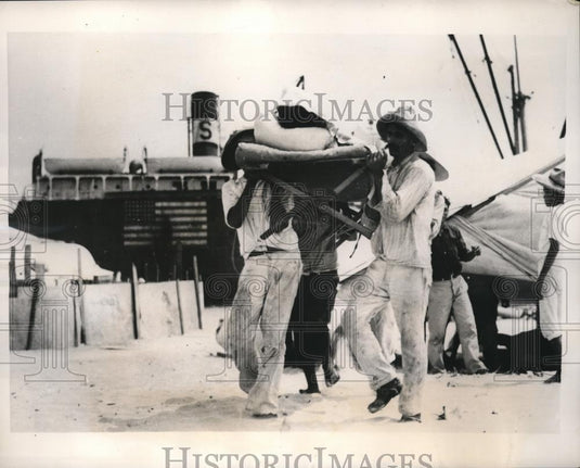 1940 Press Photo injured crew member carried away - Historic Images