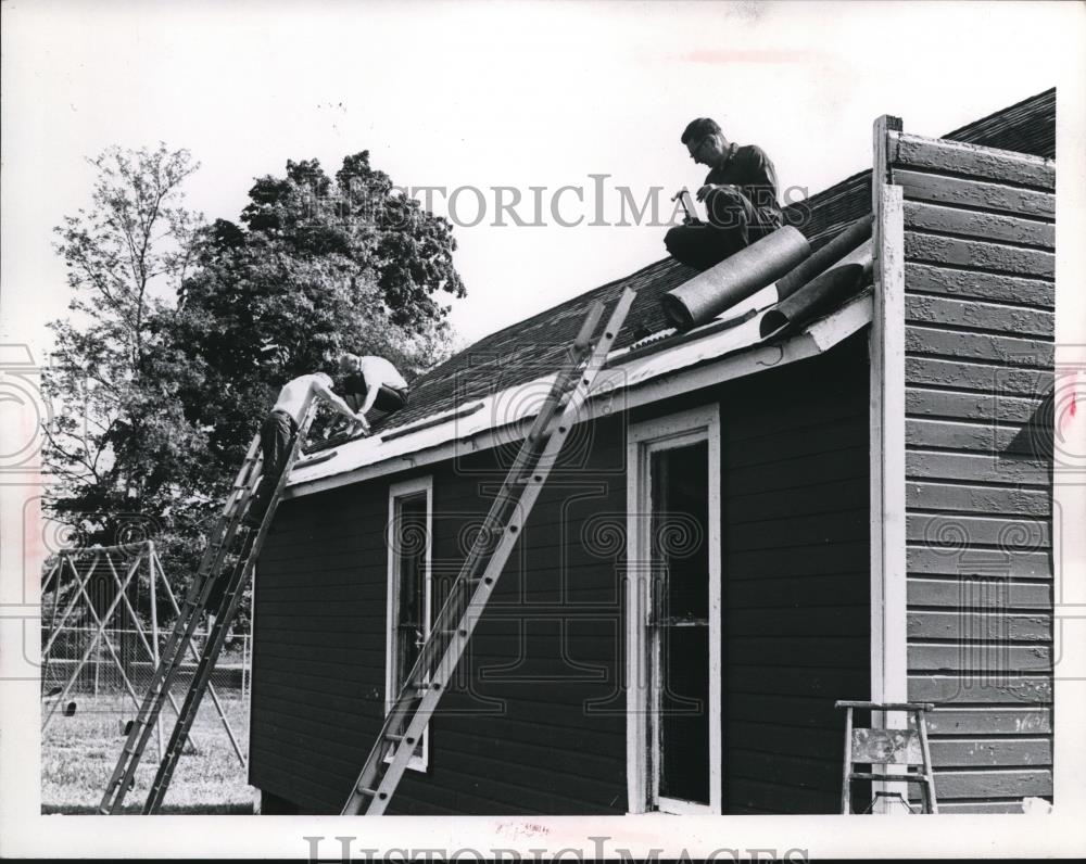 Press Photo Men working on roof repairs of a Cleveland Ohio home - nee13294 - Historic Images