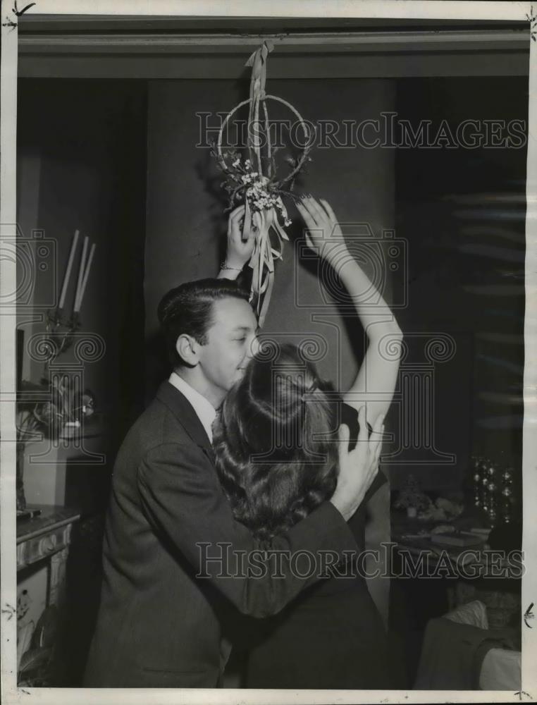 1947 Press Photo Couple Kisses Under Christmas Mistletoe - nee12445 - Historic Images