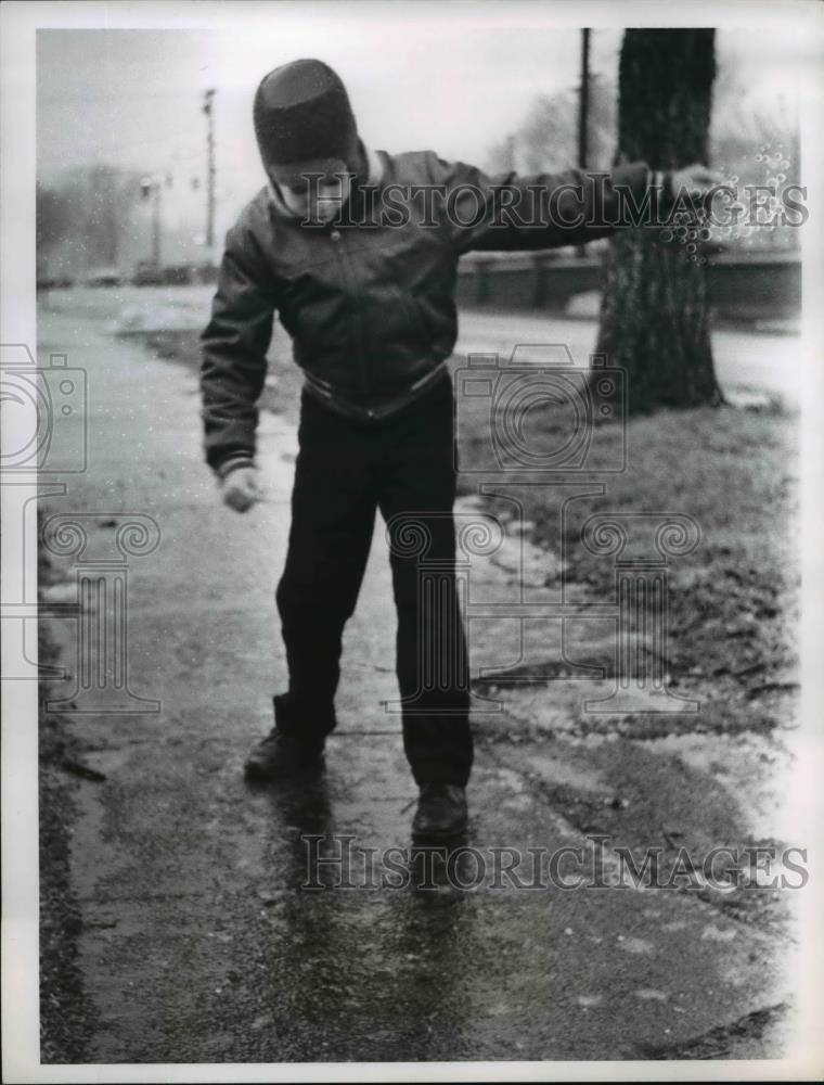 1962 Press Photo Jeff Fox stands on icy sidewalk - Historic Images