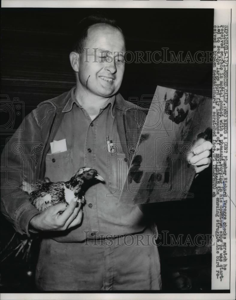 1958 Press Photo Richard Veregge holding a bird while checking his scratch face - Historic Images