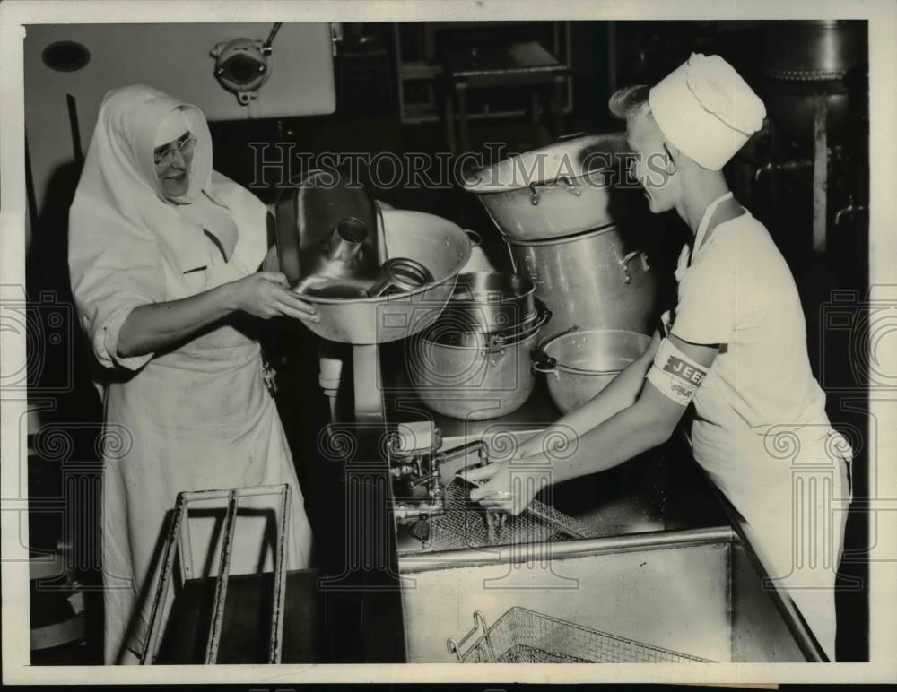 1943 Press Photo Don Lauer and the Nun in charge cleaning the kitchenwares - Historic Images