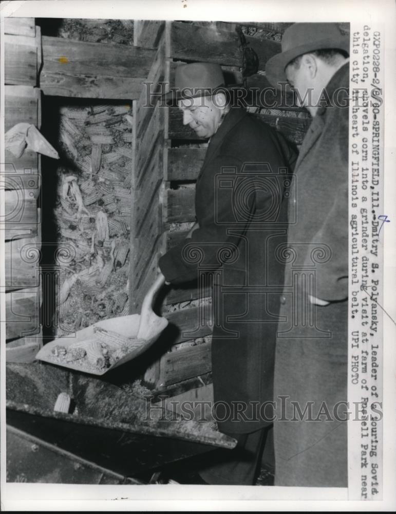 1960 Press Photo Dmitry S. Polyansky shovels corn into grinder at farm - Historic Images