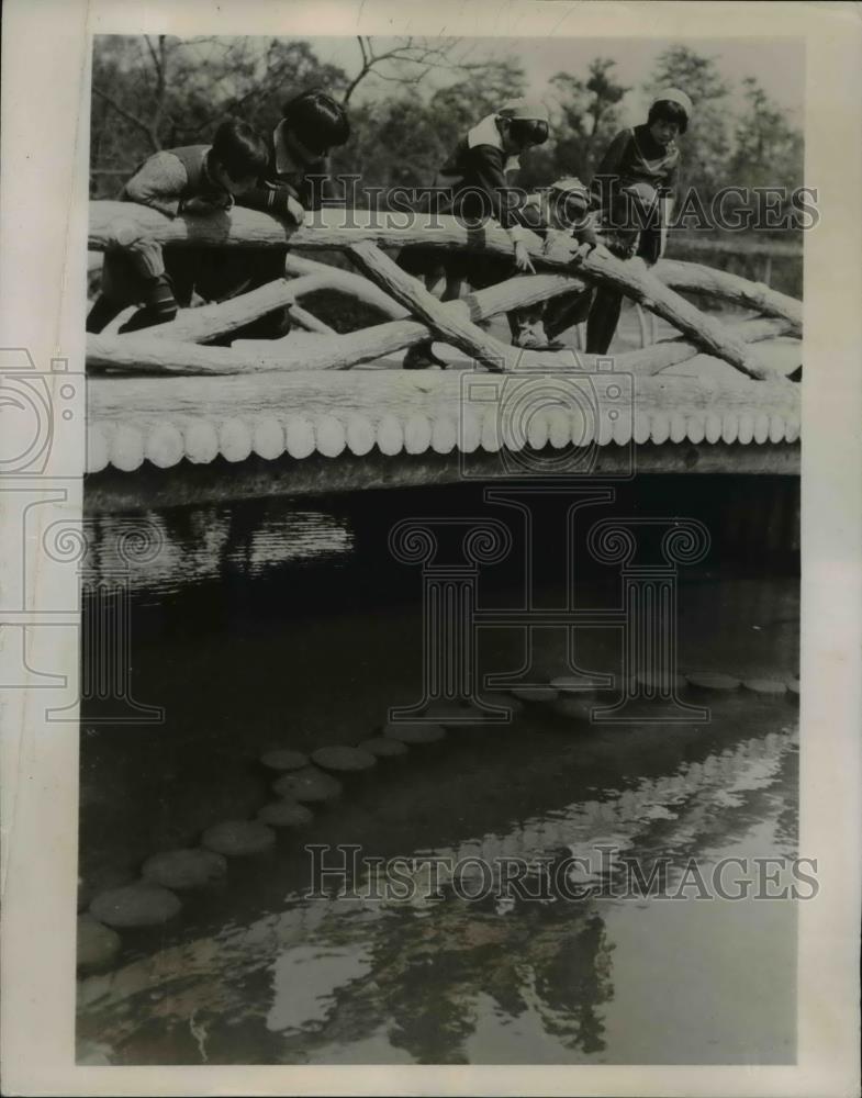 1936 Press Photo Tokyo Youngsters pause to peer at their shadows in the water - Historic Images