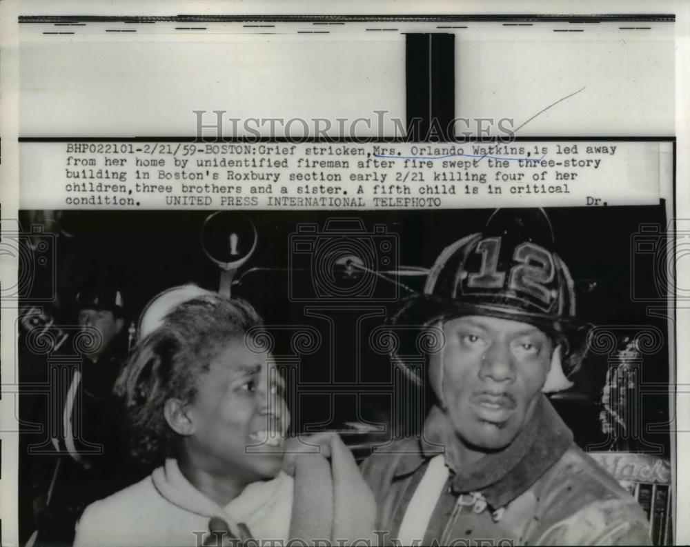 1959 Press Photo Mrs. Orlando Watkins led away from her burning home by fireman - Historic Images