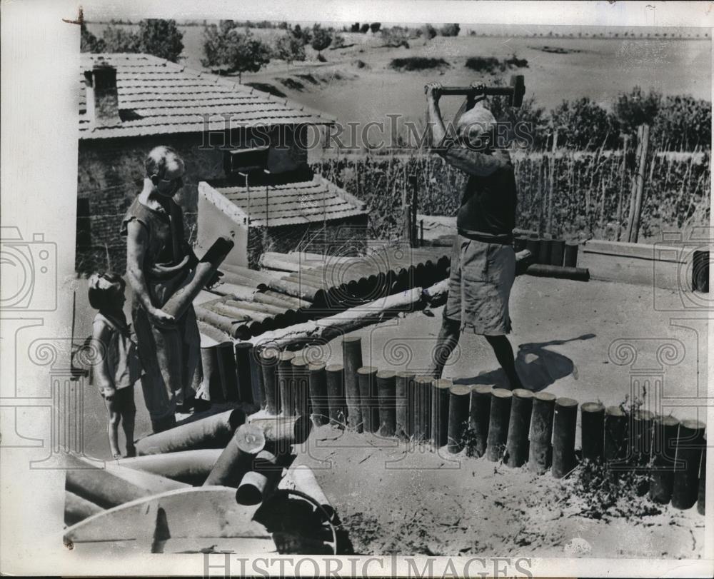 1945 Press Photo Italian farmer beats shell cases into fences in Italy - Historic Images