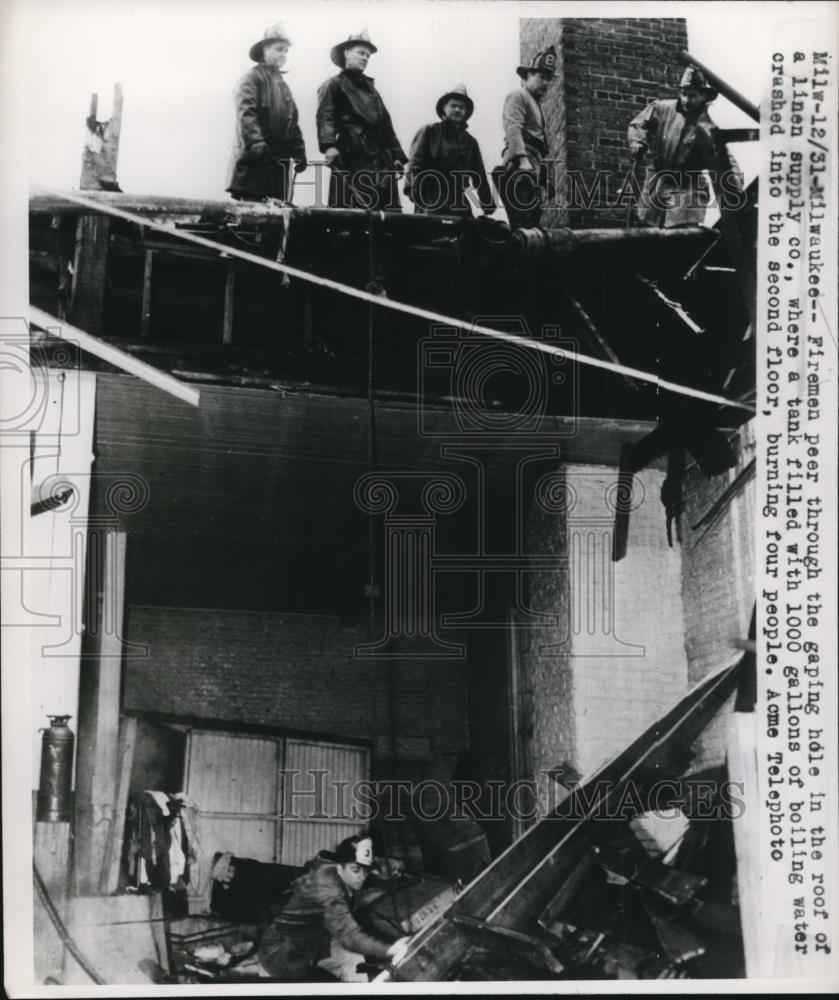 1948 Press Photo Firemen peer through gaping hole in roof of linen supply co - Historic Images