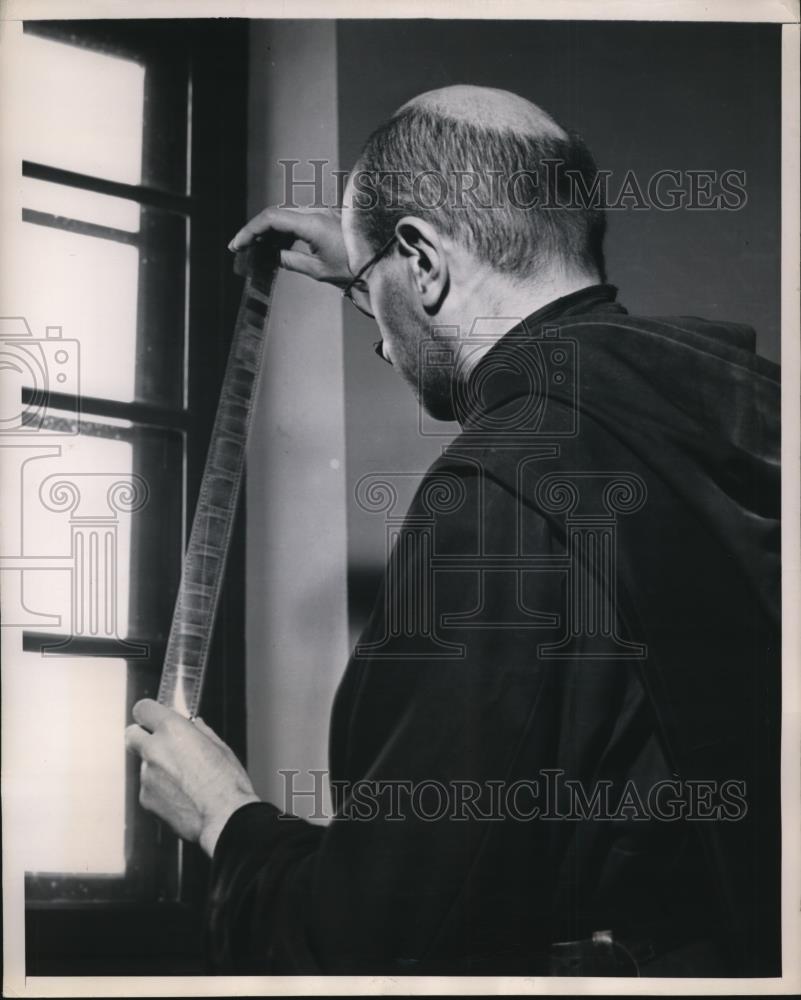 1948 Press Photo Father Dufourg checks film as a bible editor - Historic Images