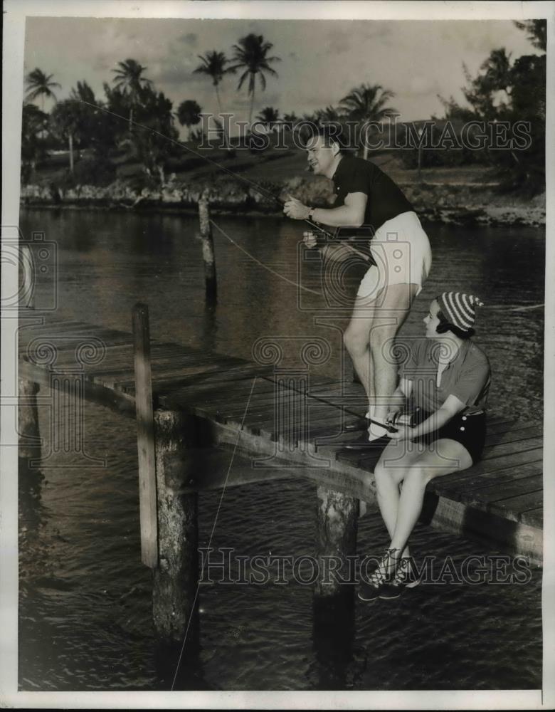 1938 Press Photo Mrs. Guernsey Curran Jr. looks at her husband reeling in fish - Historic Images