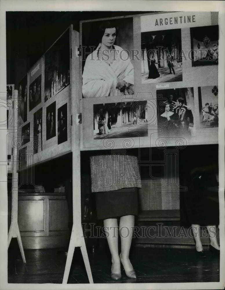 1958 Press Photo of woman standing behind a photo board from Argentine. - Historic Images