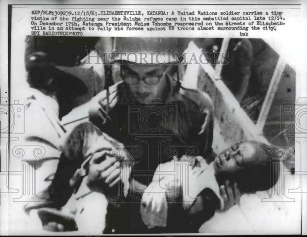 1961 Press Photo of a UN soldier carrying a wounded child in Elisabeth, Katanga. - Historic Images