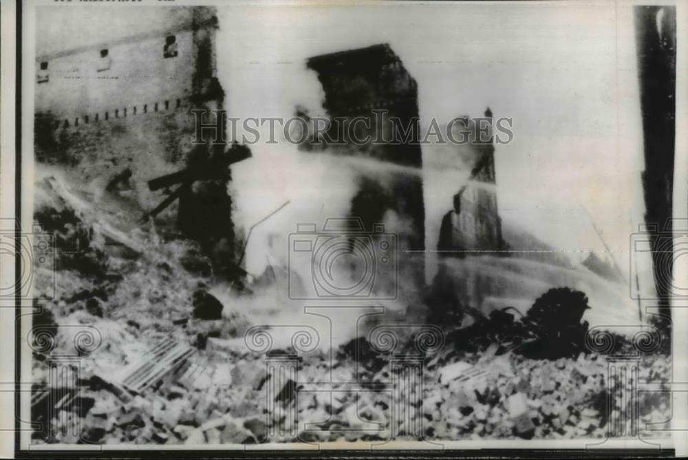 1960 Press Photo fireman spray water on smoldering remains of warehouse - Historic Images