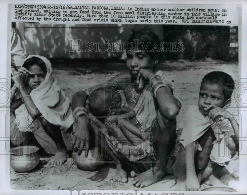 1966 Press Photo Indian Mother and Children wait to get food in India - Historic Images