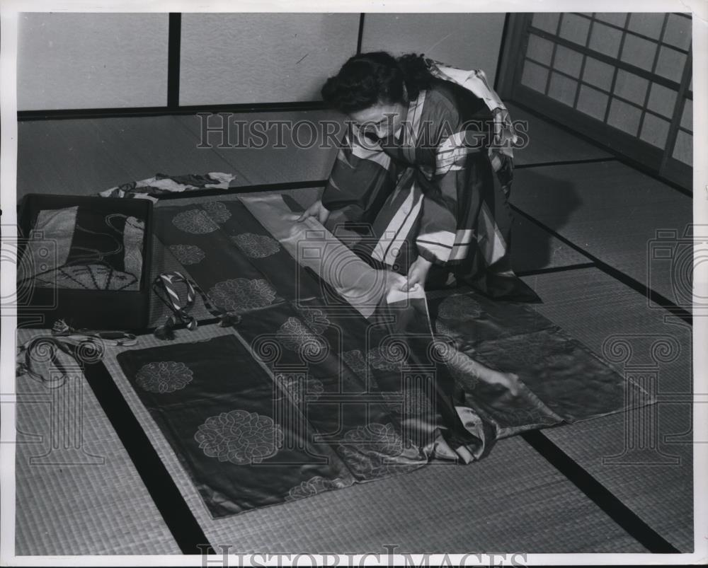 1949 Press Photo A Japanese woman folding a kimono for storage - Historic Images