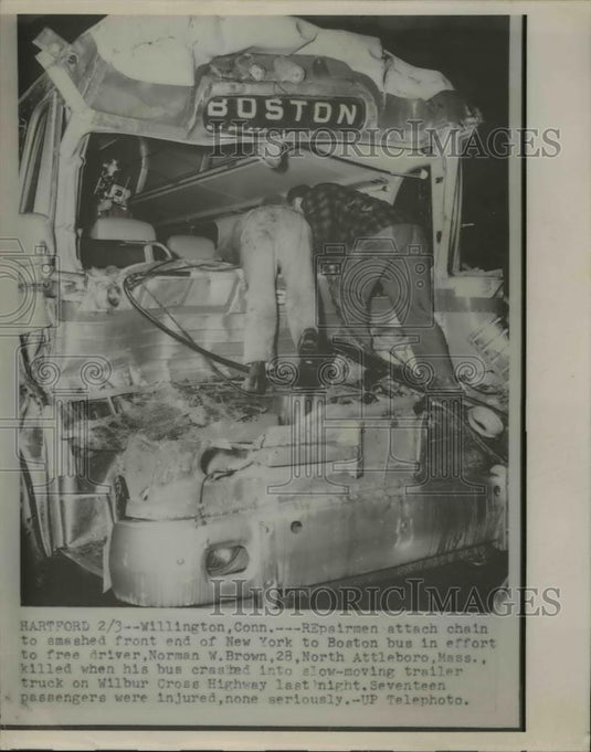 1954 Press Photo repairmen attach chain to smashed front end of bus. - Historic Images