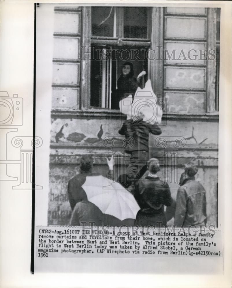 1961 Press Photo A group of West Berliners help a family remove curtain and - Historic Images