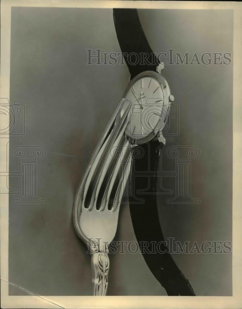 1960 Press Photo Close Up of Wristwatch Held Between Tines of Fork - Historic Images