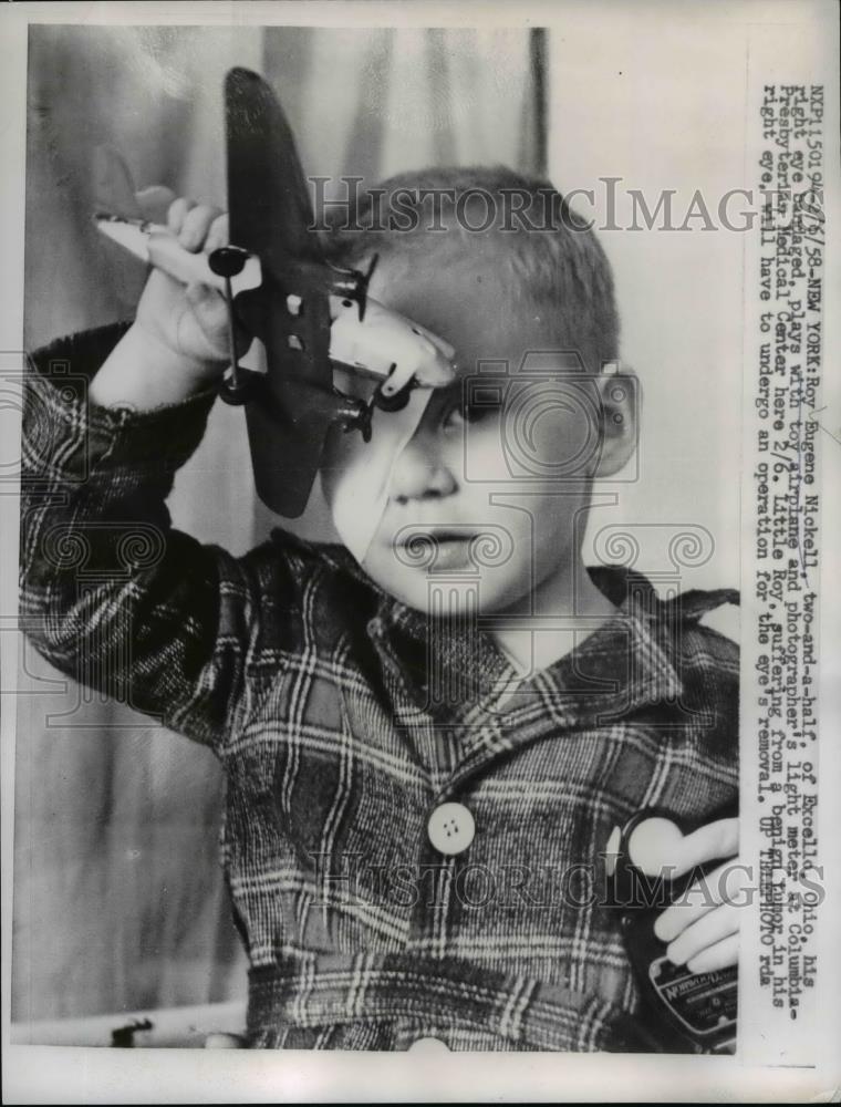 1958 Press Photo Roy Eugene Nickell Plays with Toy airplane eye removal - Historic Images