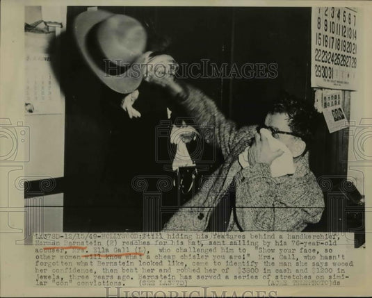 1949 Press Photo Herman Bernstein reaches for hat sent sailing by Mrs Ella Call. - Historic Images