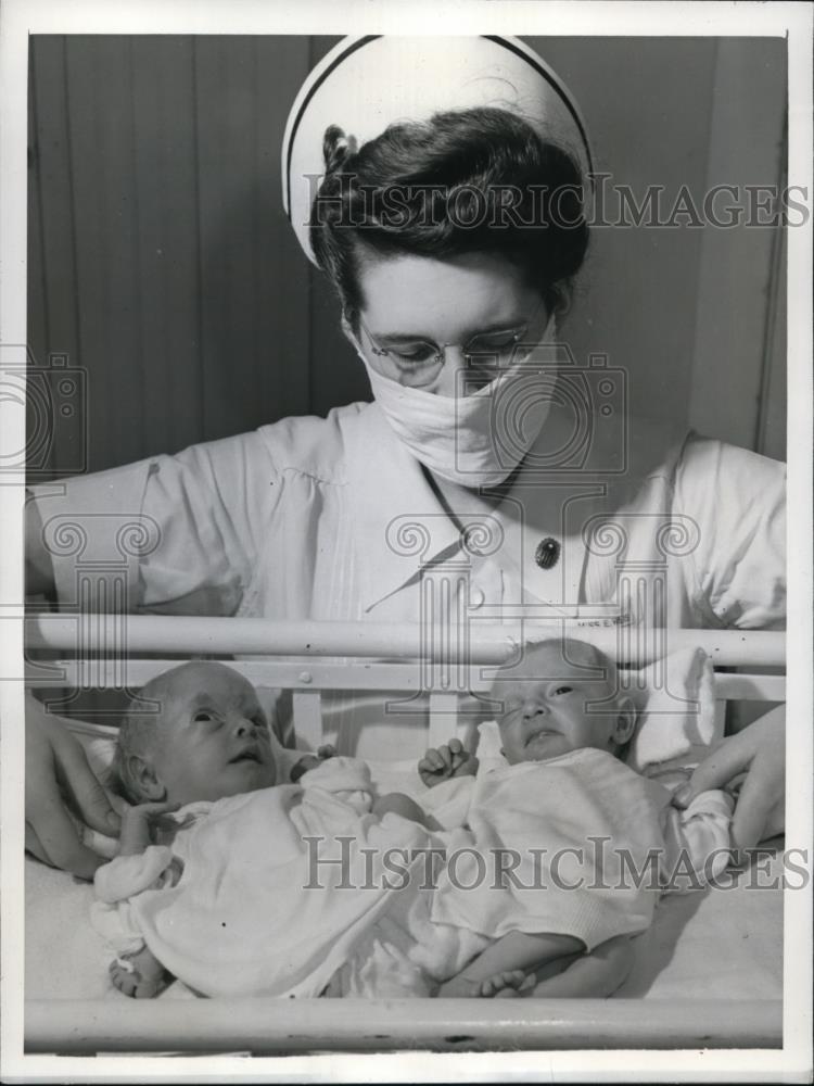 1942 Press Photo Nurse Eileen Weis tends Janet Mary and Judith Ann Sabers. - Historic Images