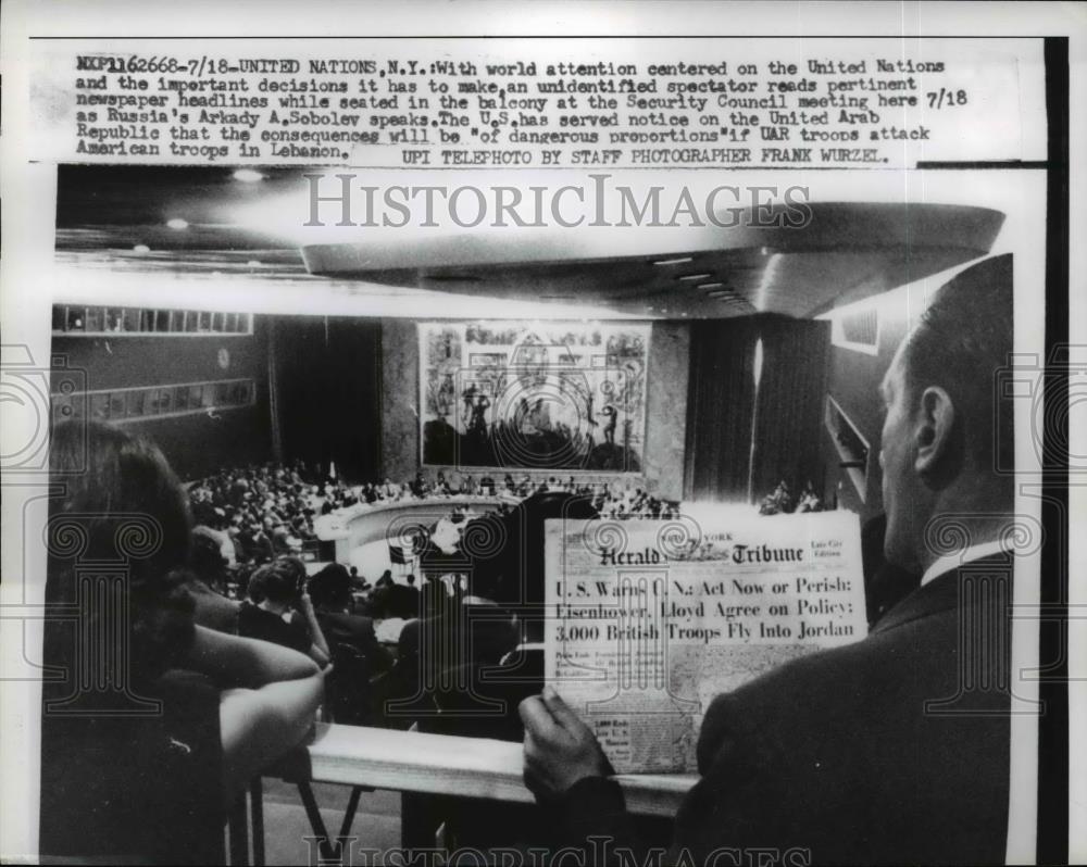 1958 Press Photo United Nations Unidentified spectator reads headline in balcony - Historic Images