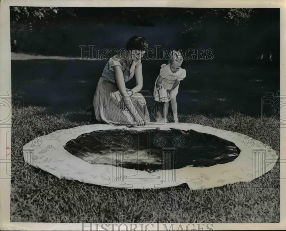 1953 Press Photo A mother and daughter put away the summer swimming hole - Historic Images