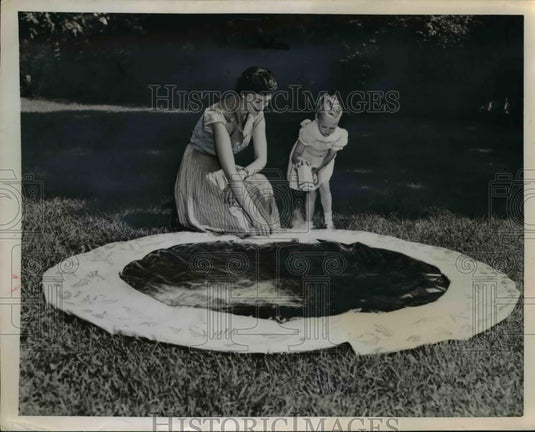 1953 Press Photo A mother and daughter put away the summer swimming hole - Historic Images