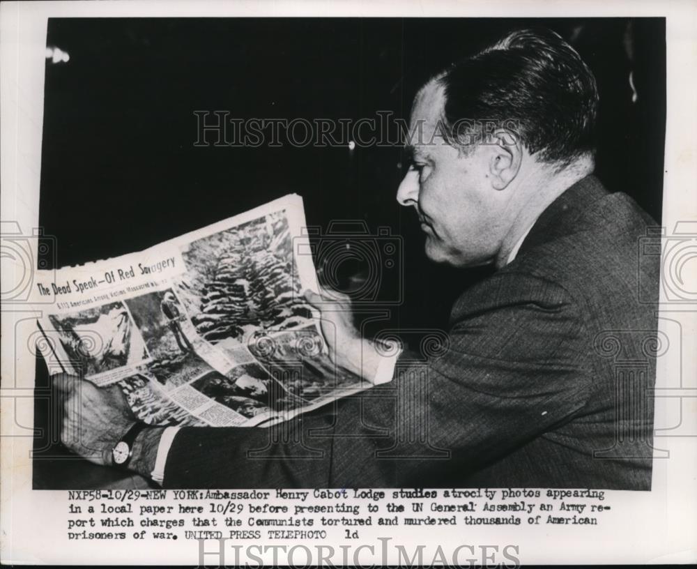 1953 Press Photo Amb.Henry Cabot Lodge studies atrocity photos in local paper. - Historic Images