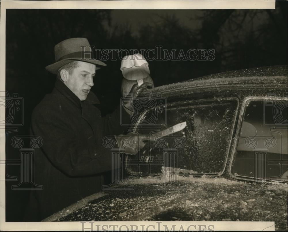 1940 Press Photo Preston Bery removing sleet from an Automobile with shield. - Historic Images