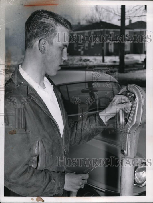 1959 Press Photo Ed Schuler places a coin in a parking meter in Shaker Heights - Historic Images