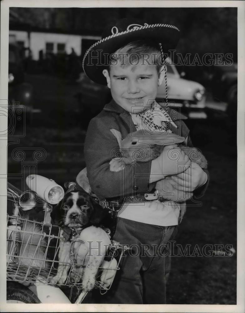 1953 Press Photo Donny Thompson snuggles pet bunny near his puppy and bike. - Historic Images