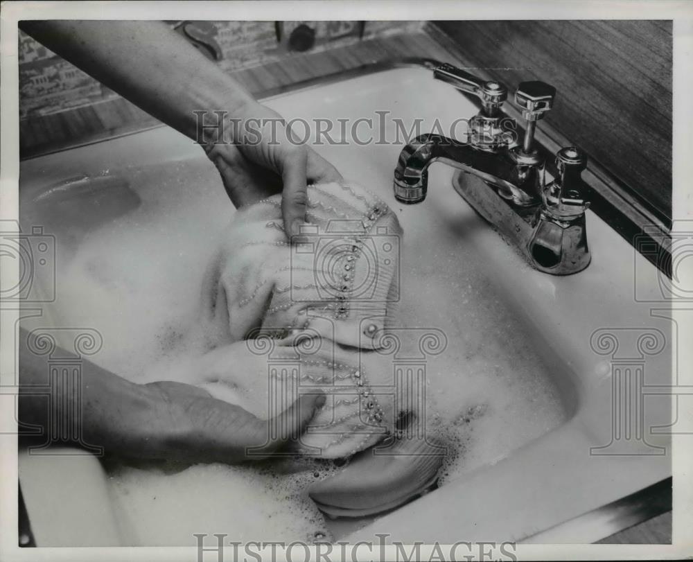 1953 Press Photo A woman demonstrates hand washing of sweater fabrics - Historic Images