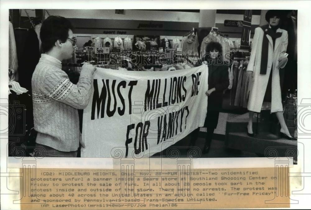 1986 Press Photo Two unidentified protestors with the banner inside the Sears - Historic Images