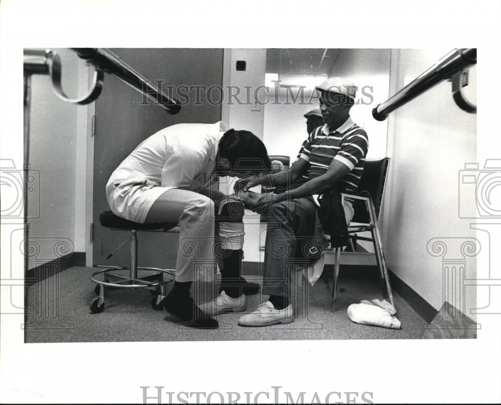 1991 Press Photo Thomas checks the adjustments on Raymond Hurd&#39;s limb - Historic Images