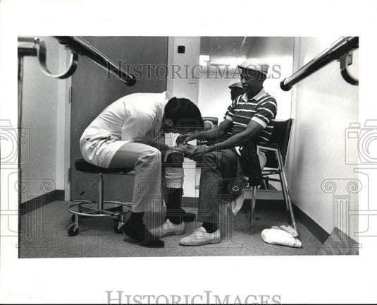 1991 Press Photo Thomas checks the adjustments on Raymond Hurd's limb - Historic Images