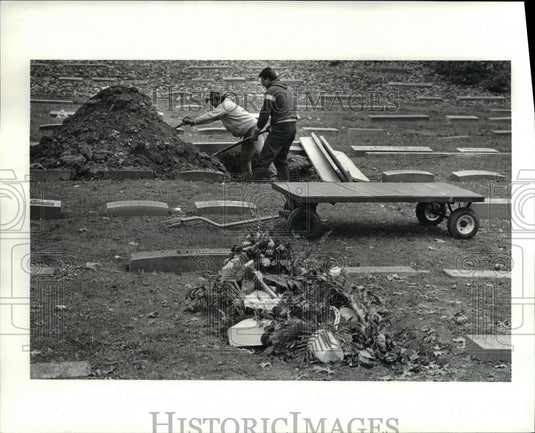 1986 Press Photo Carmen Pinzone & Paul Brack cover a grave at Lakeview Cementery - Historic Images