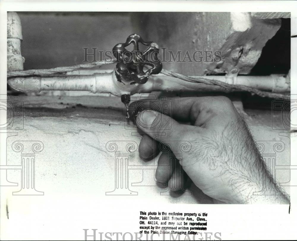 1988 Press Photo Shutting off the vales to outside water faucet - cva75305 - Historic Images