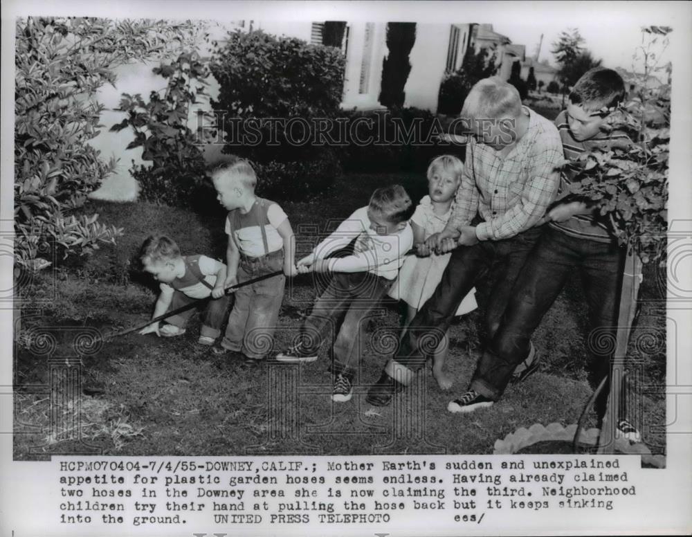 1955 Press Photo Downey California boys pull a hose from the ground at sinkhole - Historic Images