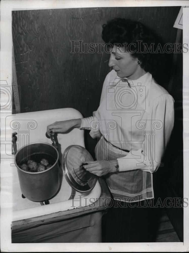 1947 Press Photo A housewife with potatoes to be peeled at her kitchen sink - Historic Images