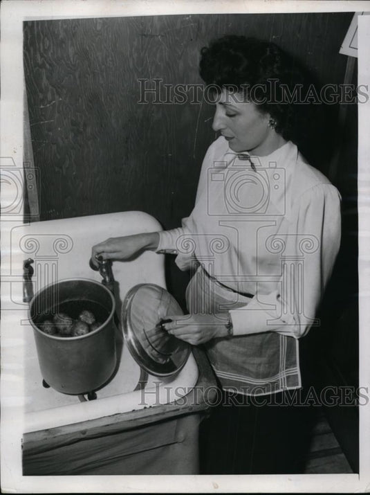 1947 Press Photo A housewife with potatoes to be peeled at her kitchen sink - Historic Images