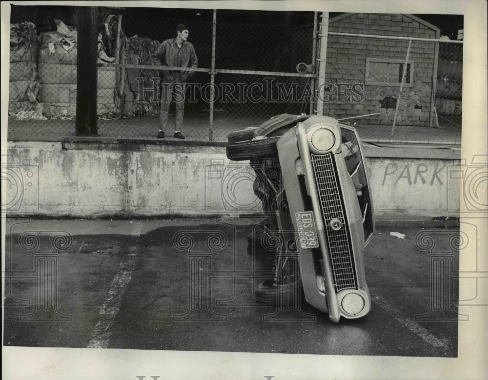 1969 Press Photo Small car lies forlornly on its side at Fry Roofing Co - Historic Images