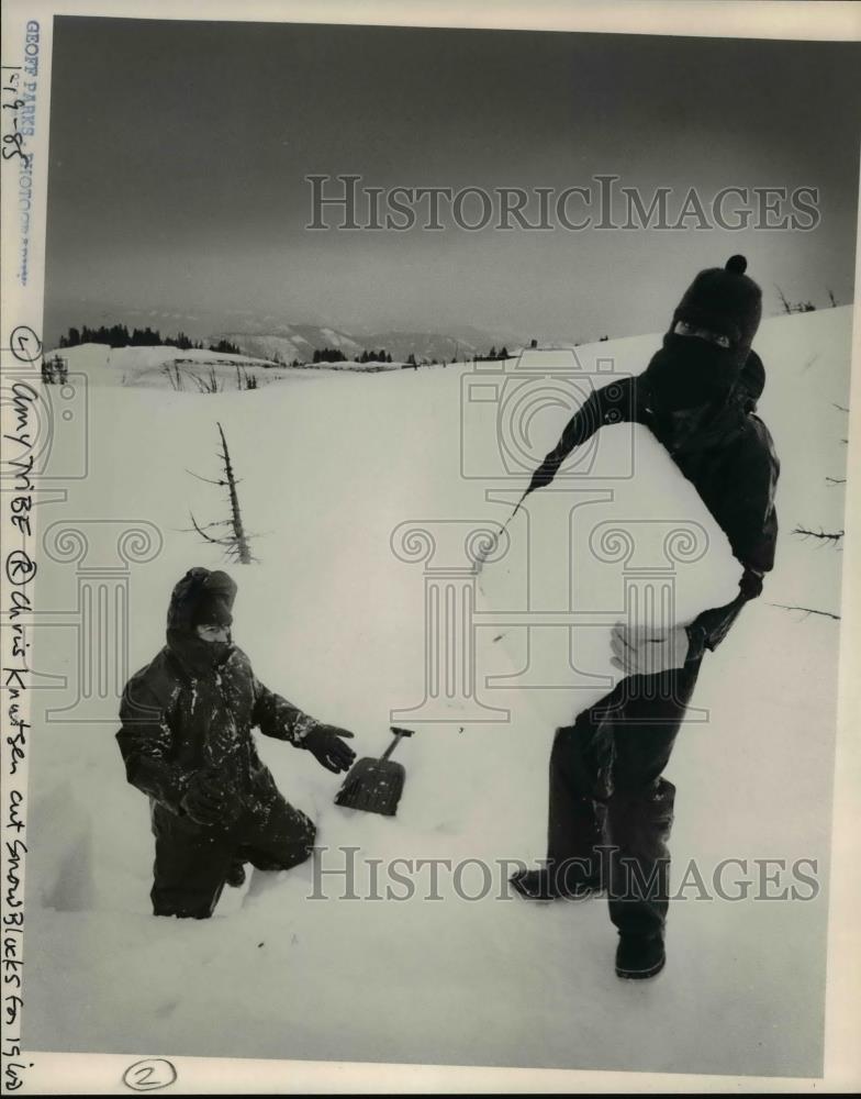 1985 Press Photo Amy Tribe (left) and Chris Knutson carve Igloo blocks of snow - Historic Images