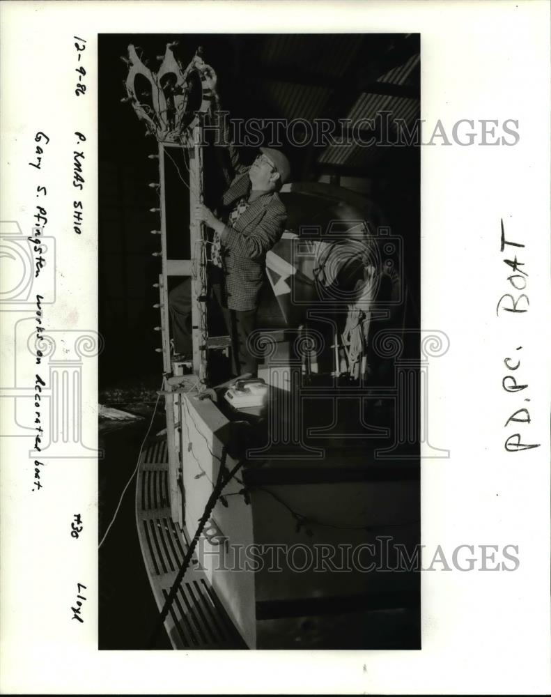 1986 Press Photo Gary Pfingsten adjusts Christmas lights on his boat - orb10622 - Historic Images