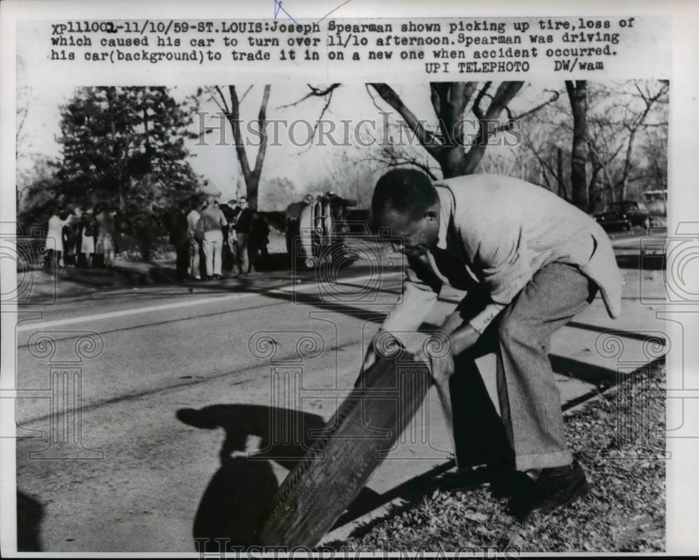 1959 Press Photo Joseph Spearman picks up tire after accident in St Louis - Historic Images