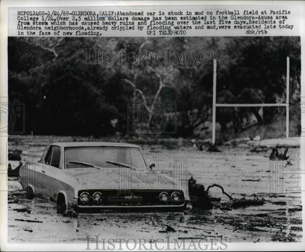 1969 Press Photo Abandoned car stuck in mud at football field in Pacific College - Historic Images