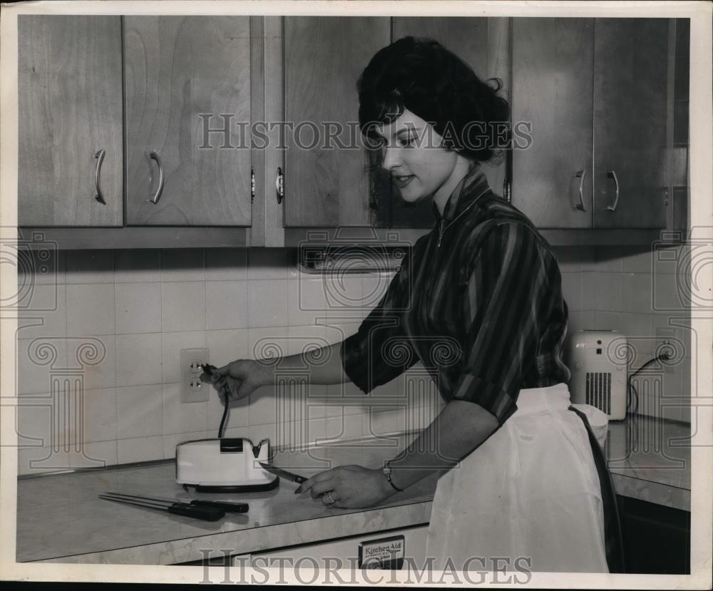 1961 Press Photo Woman plugs knife sharpener into kitchen outlet - nee94141 - Historic Images