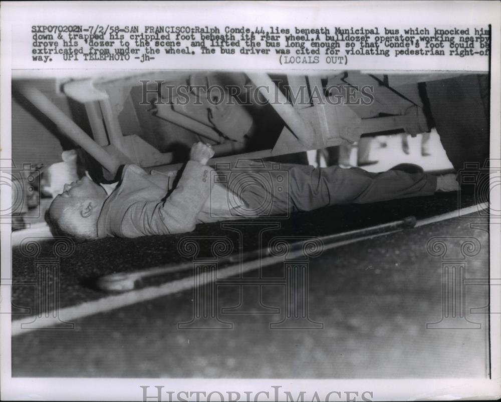 1958 Press Photo Ralph Conde Lies beneath The Municipal Bus - nee96060 - Historic Images