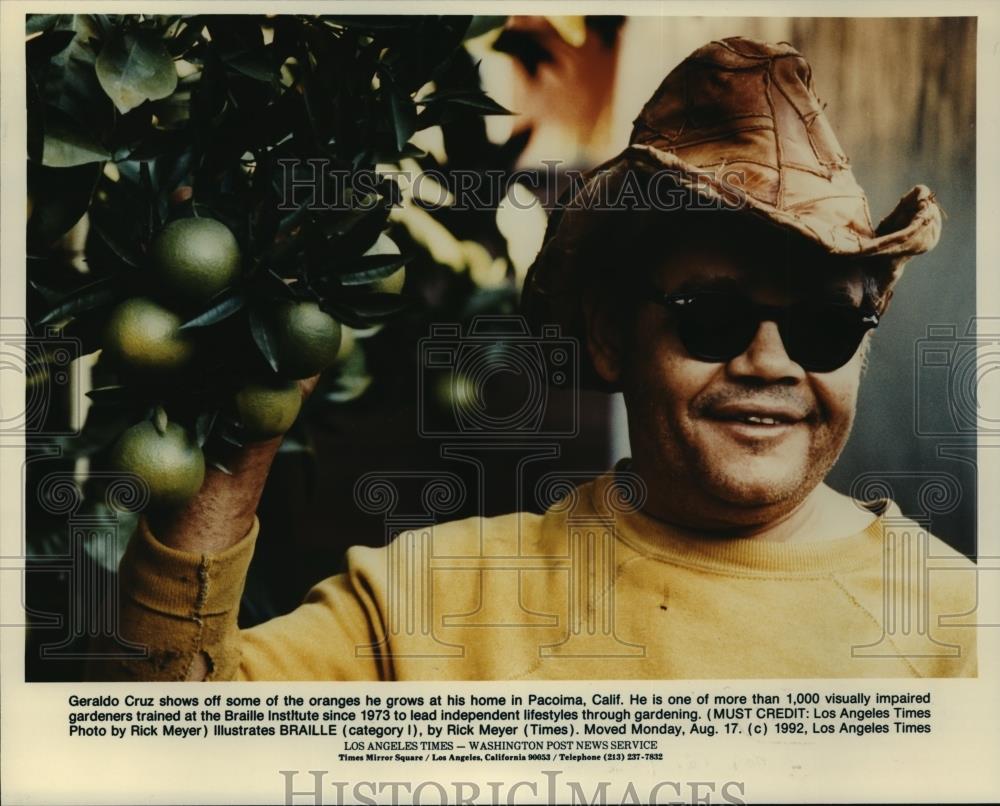1992 Press Photo Geraldo Cruz shows off some of the oranges he grows. - Historic Images